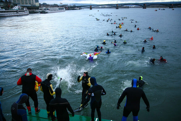 Bei Silvesterabschwimmen springen Feuerwehrleute in den kalten Rhein.