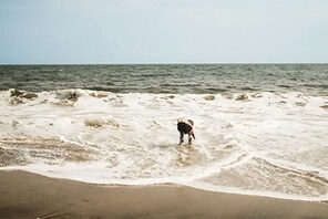 Blick auf das Meer mit einem Mensch, der sich zum Wasser beugt. © Institut Français Benga Mavinga