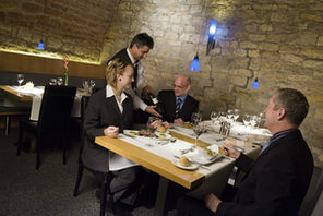 Ein Somelier präsentiert drei Gästen eine Flasche Wein. © Novotel Mainz