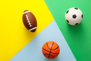 Ein Football, ein Basketball und ein Fußball auf buntem Untergrund © AdobeStock Pixel Shot